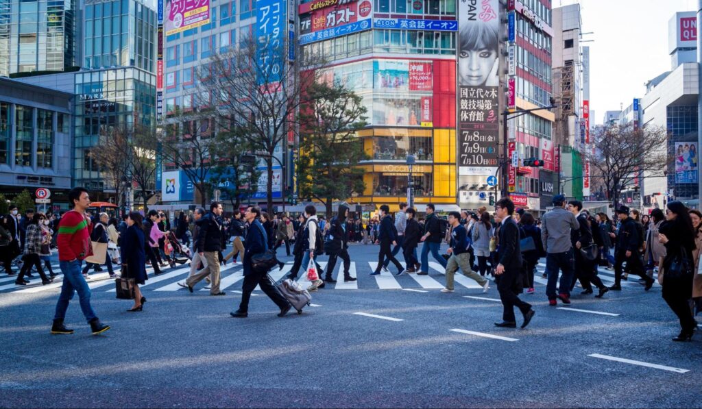Shibuya scramble crossing with people walking across on their way to work in Japan.
