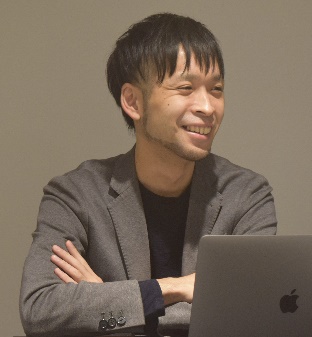 A smiling software engineer working on a computer in Japan.
