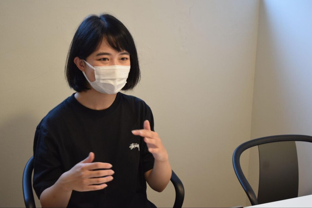 A woman sitting in a chair being interviewed about working as a designer in Japan.